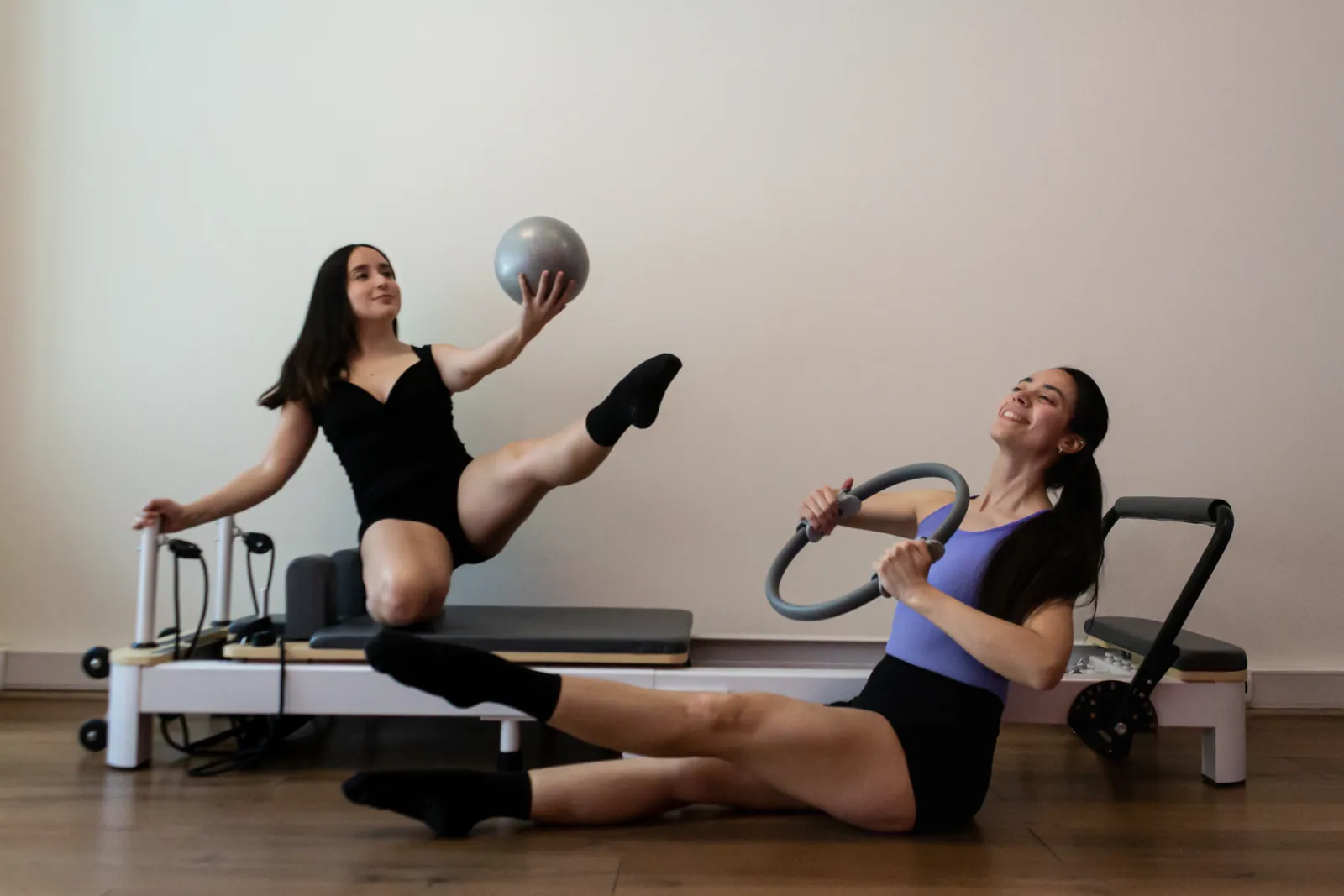 Las profesoras de Elevé en el estudio, una con la pelota y otra con el aro, sonriendo.