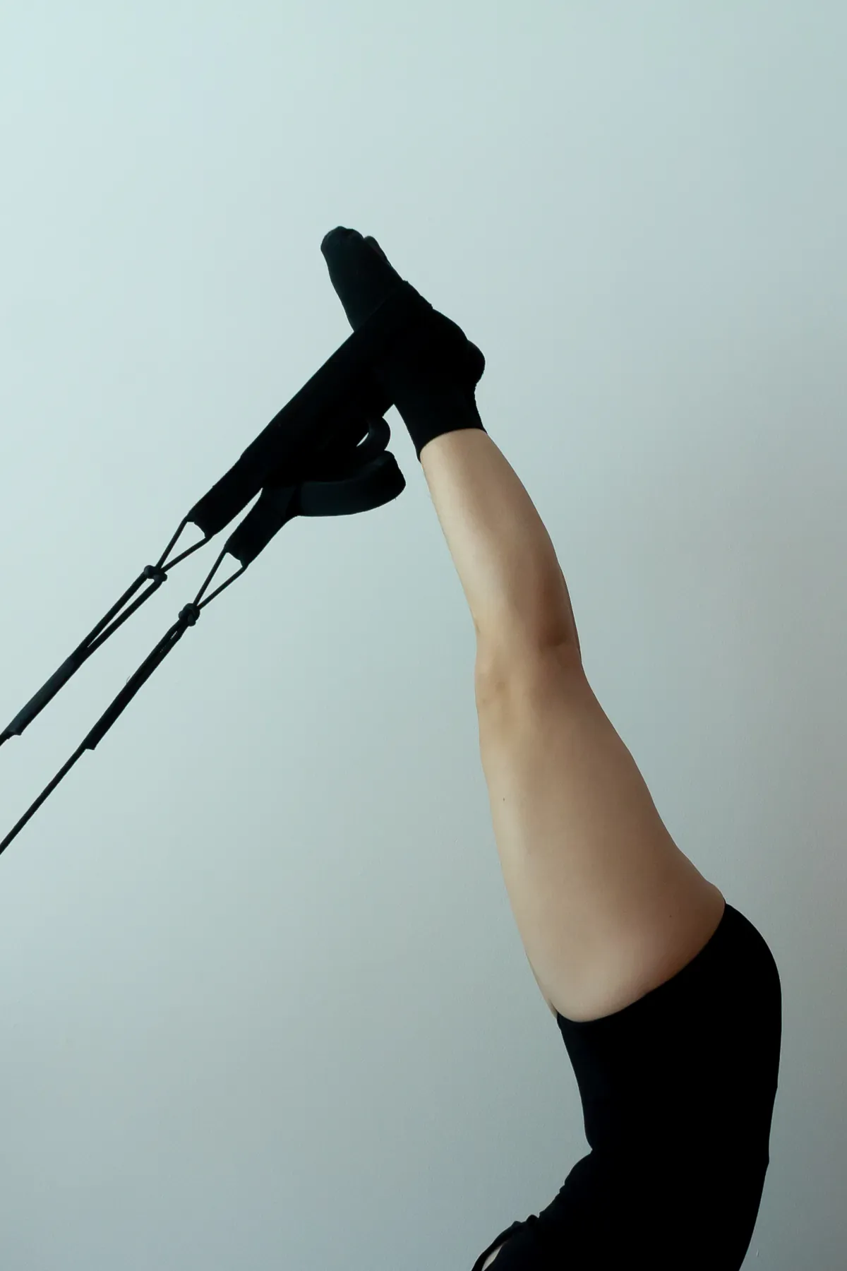 Piernas en alto con los pies en las correas del reformer.